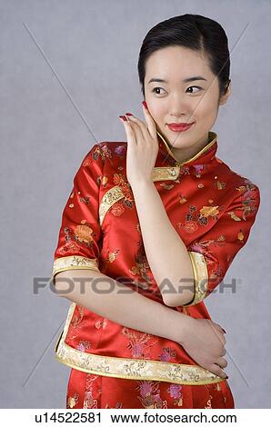 Stock Image - Young woman in cheongsam posing. Fotosearch