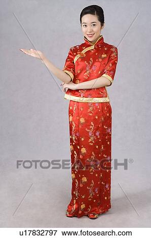 Stock Photo - Young woman in Cheongsam reaching her right hand. Fotosearch