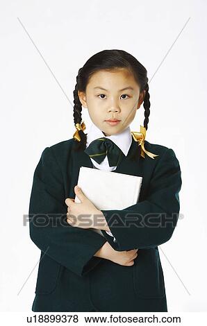 Girl in school uniforms holding a book in the bosom View Large Photo Image Stock Photo - Girl in school uniforms holding a book in the bosom. Fotosearch