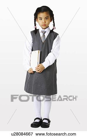 Stock Photo - Girl in school uniforms holding a book. Fotosearch
