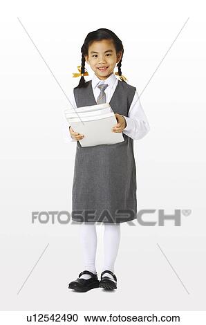 Stock Image - Girl in school uniforms holding three books. Fotosearch
