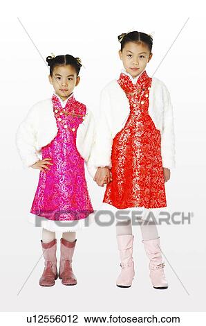 Stock Image - Girl in traditional dress hand in hand. Fotosearch