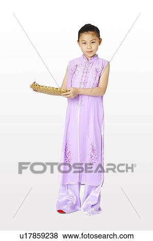 Stock Photo - Girl in traditional dress holding a dustpan. Fotosearch