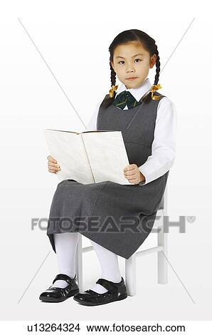 Girl sitting on the chair holding a book View Large Photo Image Picture - Girl sitting on the chair holding a book. Fotosearch