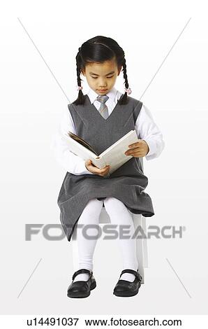 Girl sitting on the chair reading a book View Large Photo Image Stock Photo - Girl sitting on the chair reading a book. Fotosearch