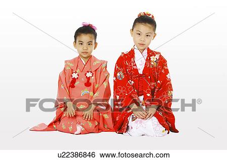 Stock Photograph - Girls in kimono sitting on the floor. Fotosearch