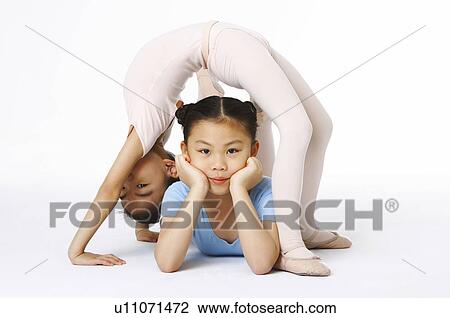 Stock Image - One girl bend down her body over the other girl. Fotosearch