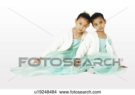 Picture - Two girls leaning against each other. Fotosearch