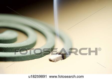 Stock Image - Burning mosquito coil incense, close-up. Fotosearch