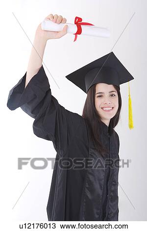 Stock Image - A young woman holding certificate, smiling, portrait, People,. Fotosearch