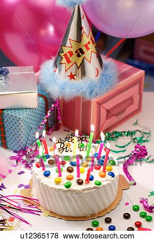 Birthday cake, party hat and wrapped gifts View Large Photo Image Stock Photo - Birthday cake, party hat and wrapped gifts. Fotosearch