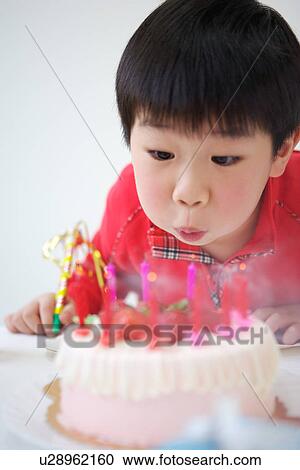 Boy browing candles at birthday party View Large Photo Image Stock Image - Boy browing candles at birthday party. Fotosearch