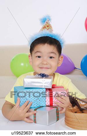 Boy holding stack of Christmas presents, smiling, portrait View Large Photo Image Stock Photo - Boy holding stack of Christmas presents, smiling, portrait . Fotosearch