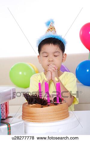 Boy making wish in front of birthday cake View Large Photo Image Stock Photo - Boy making wish in front of birthday cake. Fotosearch