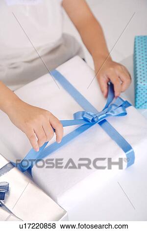 Girl about to opening wrapped gift, mid section View Large Photo Image Stock Photo - Girl about to opening wrapped gift, mid section. Fotosearch