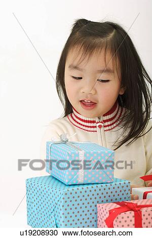 Girl looking at wrapped gifts, smiling, portrait View Large Photo Image Stock Image - Girl looking at wrapped gifts, smiling, portrait. Fotosearch