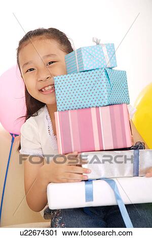 Girl sitting on sofa with stacked wrapped gift on her knee View Large Photo Image Stock Image - Girl sitting on sofa with stacked wrapped gift on her knee. Fotosearch