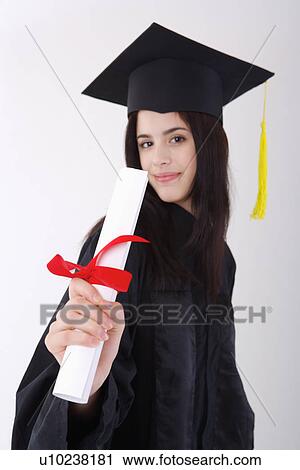 One young woman wearing graduation gown holding certificate View Large Photo Image Stock Image - One young woman wearing graduation gown holding certificate. Fotosearch