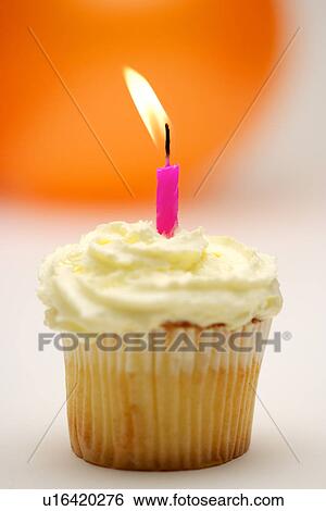 Stock Photograph - Single burning candle on cupcake. Fotosearch