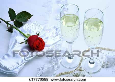 Stock Photo - Single rose, pearl necklace, white glove and wineglasses with beer. Fotosearch