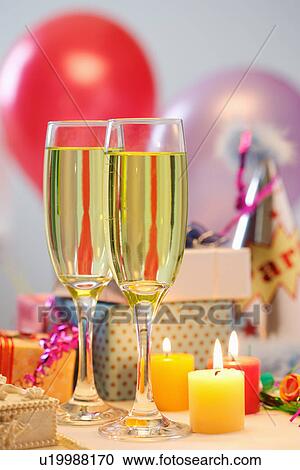 Stock Image - Wineglasses with beer, candles, gifts. Fotosearch
