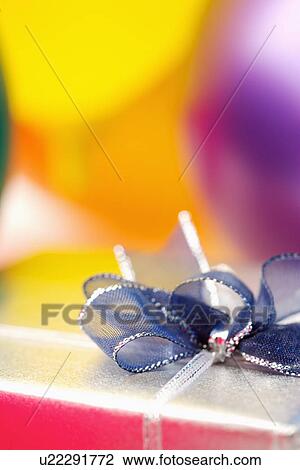 Stock Image - Wrapped gift with blue ribbon. Fotosearch