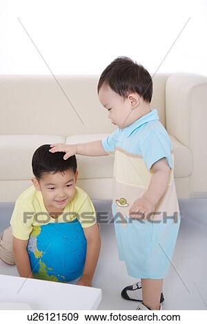 Baby boy touching boy's head View Large Photo Image Stock Photo - Baby boy touching boy's head. Fotosearch