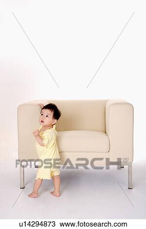 Baby girl standing by sofa looking up View Large Photo Image Stock Image - Baby girl standing by sofa looking up. Fotosearch