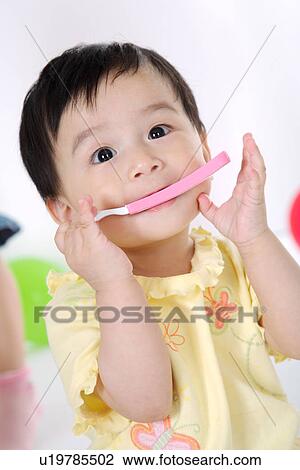 Baby girl with spoon in mouth View Large Photo Image Stock Image - Baby girl with spoon in mouth. Fotosearch