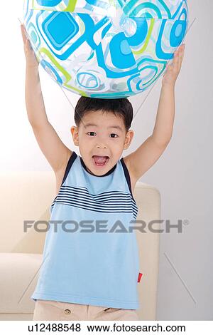 Stock Photo - Boy carrying globe on head. Fotosearch