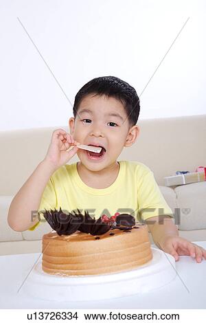 Boy eating birthday cake View Large Photo Image Picture - Boy eating birthday cake. Fotosearch