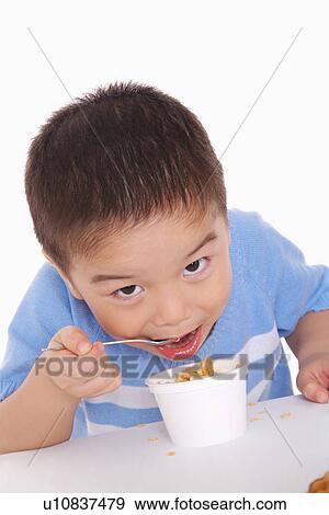 Boy eating food, portrait View Large Photo Image Stock Photo - Boy eating food, portrait. Fotosearch