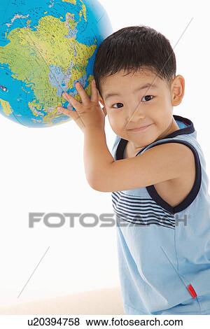 Boy lifting up globe, smiling, portrait View Large Photo Image Stock Photo - Boy lifting up globe, smiling, portrait. Fotosearch
