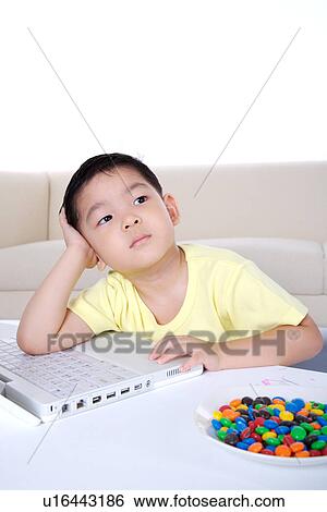 Stock Photograph - Boy with head in hands thinking. Fotosearch