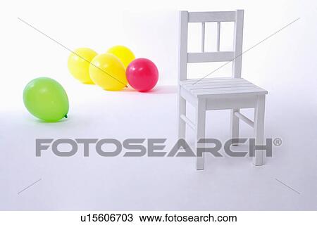 Stock Image - Chair and balloons on floor. Fotosearch