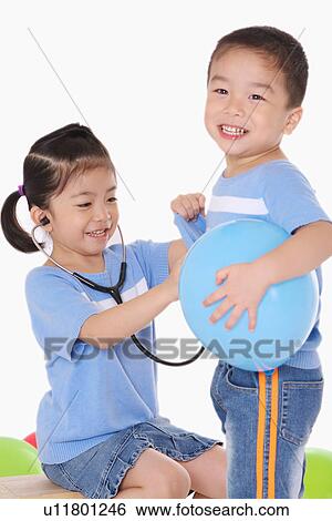 Girl (4-6) using stethoscope on boy View Large Photo Image Stock Photograph - Girl (4-6) using stethoscope on boy. Fotosearch