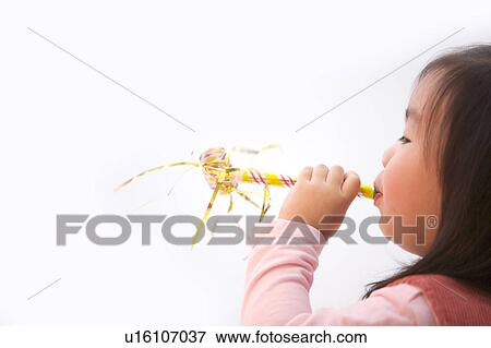 Girl blowing party horn blower View Large Photo Image Stock Photo - Girl blowing party horn blower. Fotosearch