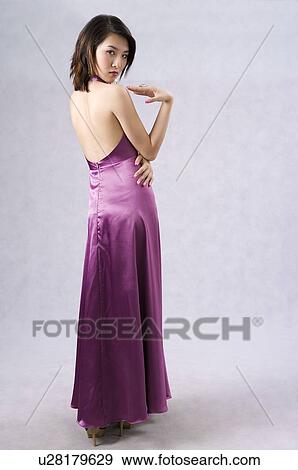 Young woman in purple evening gown, rear view, head turned View Large Photo Image Stock Photo - Young woman in purple evening gown, rear view, head turned. Fotosearch