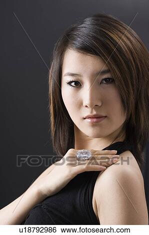 Stock Photograph - Young woman showing a ring on her hand, hand on shoulder. Fotosearch