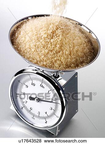 Stock Photo - Brown Rice Pouring Into Kitchen Scales - Non Exclusive. Fotosearch