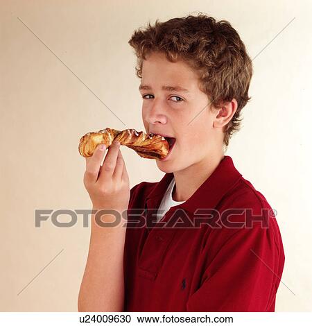 Stock Image - Child eating croissant. Fotosearch