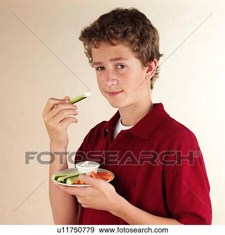 Child eating vegetable dip View Large Photo Image Stock Photo - Child eating vegetable dip. Fotosearch