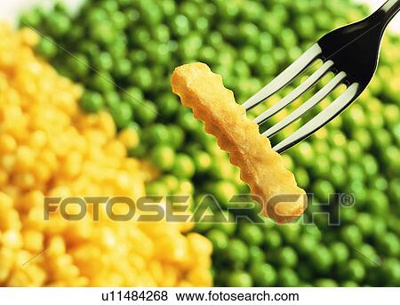 Chip on fork with peas View Large Photo Image Stock Photo - Chip on fork with peas. Fotosearch