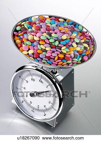 Stock Image - Kitchen Scales Filled With Sweets - Non Exclusive. Fotosearch
