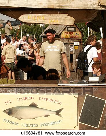Stock Image - Smoked herring stand with kipper man and kipper house. Fotosearch