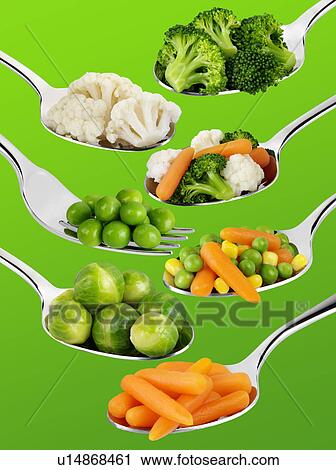 Stock Image - Spoons With Vegetables on Green - Non Exclusive. Fotosearch
