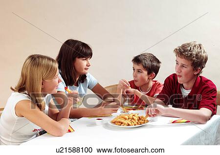Stock Image - Children eating chips. Fotosearch