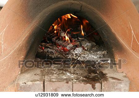 Stock Photo - Clay oven with glowing embers and flames. Fotosearch