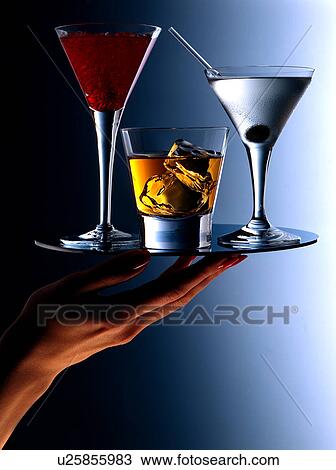 Stock Image - Cocktails on a tray with hand. Fotosearch
