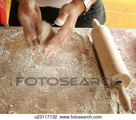 Stock Image - Making Homemade Naan Bread, Rolling Naan Bread dough, hands. Fotosearch